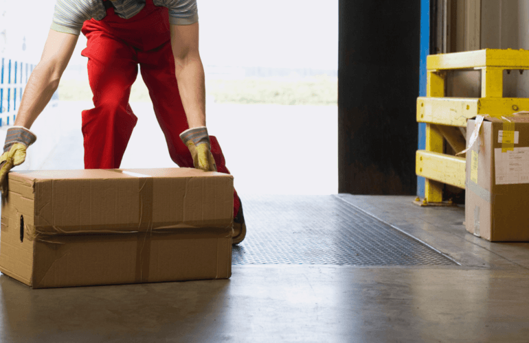 Man manually lifting a box in a manufacturing environment