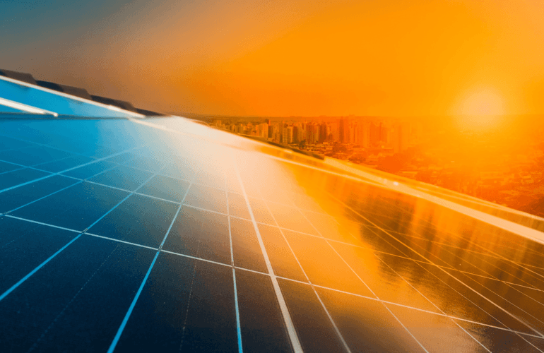 A view of a glass building with sunset on a city in the background