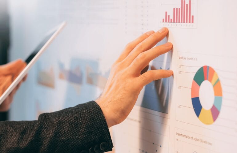 Businessman touching a wall-mounted graph with many colourful charts