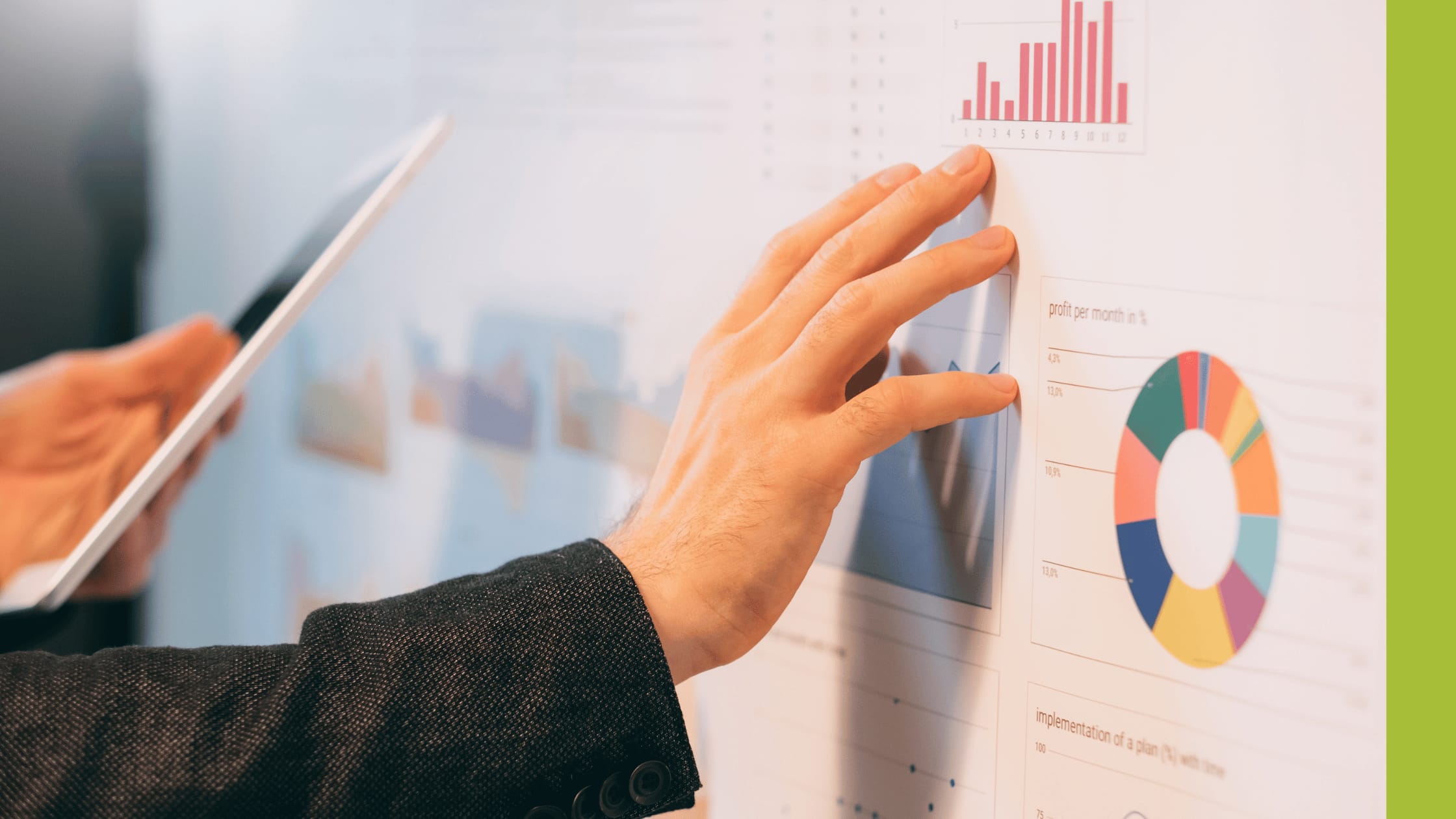 Businessman touching a wall-mounted graph with many colourful charts